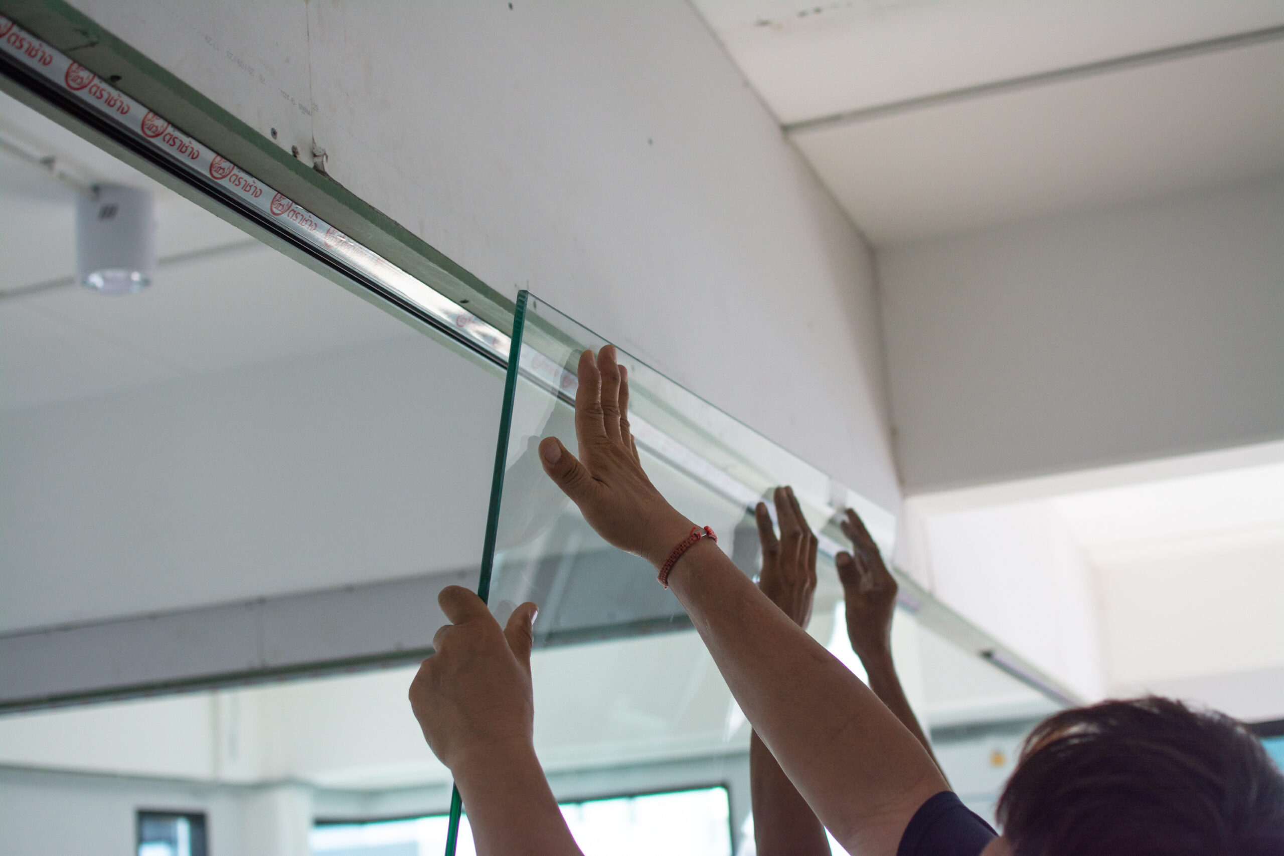Workers are installing glass wall